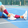 Mid-calf custom pattern socks featuring a vibrant design in red, orange, and yellow, paired with white sports shoes.