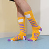 Bright yellow socks with purple accents and a logo, featuring a striped design and a towel bottom for comfort.