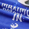 A vibrant blue sports towel with a smooth surface, featuring a logo and text against a textured background.