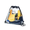 A clear PVC drawstring bag containing various items, including yellow and navy clothing, with a black drawstring and branding.