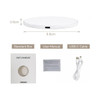 A round white wireless charger with a USB-C port, accompanied by a user manual and USB-C cable.