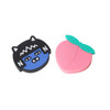 A custom-shaped PVC wireless charger in the shape of a black cat and a pink peach with green leaves.