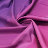 A folded fabric with a gradient blend of purple and pink hues, showcasing a smooth texture.
