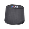 A black dashboard mat with a textured surface and a branded logo on one side.