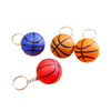 A collection of four keyrings featuring basketball-shaped stress items in blue, orange, red, and black. Each has a metal keyring.