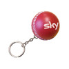 A red cricket ball stress reliever attached to a keyring, featuring a white logo.