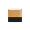 A bamboo Bluetooth wireless speaker with a black base and control buttons at the front. The top features a textured surface.