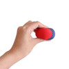 A hand holds a red and blue water bouncing ball, made of soft material, featuring a smooth surface.