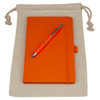 A drawstring bag in natural colour containing an orange journal book and an orange pen. The bag features a logo.
