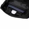 A black bag interior with a laptop and a white object visible, featuring a small zippered compartment.