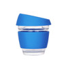 A reusable glass coffee cup featuring a clear body with a blue silicone sleeve and lid.