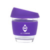 A reusable glass coffee cup with a purple silicone lid and sleeve, featuring a logo on the sleeve.