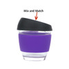 A drink bottle features a reusable glass coffee cup with a purple silicone sleeve and a black lid. It has a logo.