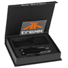 A black multi-tool set is displayed in an open box with a logo and a storage band.