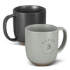 A ceramic mug set featuring a speckled black mug and a speckled green mug, both with contrasting bases and logos.
