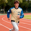 A unisex varsity jacket in beige and blue with contrasting sleeves, featuring a logo and sporty design.