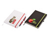 A white notepad with a cat graphic and a black notepad with an apple graphic, both featuring elastic bands.