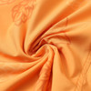 An orange fabric featuring a subtle leaf pattern, suitable for athletic wear, with a smooth texture.