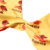 A yellow bikini top with a knot detail, featuring palm tree and beach-themed designs. It has a logo.