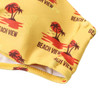 A yellow bikini top featuring a tropical design with palm trees and sunset motifs, including a logo.