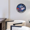 A round wall clock featuring a space theme with a rocket, in blue, white, and red colours. It has a logo.