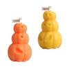 Triple pumpkin-shaped candles in orange and yellow, featuring carved pumpkin faces. Includes branding on a small flag.