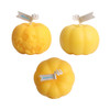 Three pumpkin-shaped candles in vibrant yellow, featuring varying designs, including one with a skull motif.