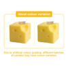Square cheese-shaped candles in bright yellow, featuring holes resembling Swiss cheese. Includes a branding logo.