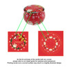 A red tin candle featuring festive cherry and Christmas-themed designs, complete with a curved lid and body.