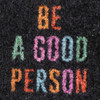 A black nylon logo mat featuring colourful text that reads "BE A GOOD PERSON."