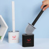 A silicone toilet brush with a black handle and white holder, featuring a logo, placed beside a modern hexagonal design.