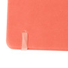 A5 PU cover notebook in coral with an elastic band closure. Features a textured finish and a logo on the cover.