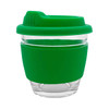A reusable coffee cup with a transparent glass body and a green silicone sleeve and lid. It features a logo.