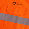 An orange unisex long-sleeve shirt featuring a reflective stripe and a pocket, with a logo on the upper left side.