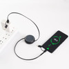 A retractable portable charging cable in black, connected to a power source and a smartphone, displaying a charging indicator.