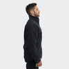 A unisex soft shell jacket in black, featuring a zipped collar and side pockets, worn by a model.