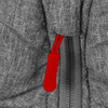 A close-up of a grey puffer jacket featuring a red zipper pull and textured fabric. The jacket has a branding logo.