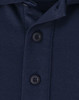 A close-up of a navy men's polo shirt featuring a button placket and collar. The fabric appears soft and sustainable.
