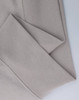 A close-up of a light beige polar fleece jumper featuring a half-zip collar. It has a simple design with a logo.