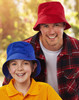 A red bucket hat and a blue bucket hat are worn by a smiling man and girl outdoors. Both hats feature a toggle.