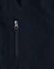 A close-up of a navy softshell jacket featuring a zippered pocket. The fabric appears smooth and durable.