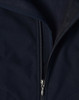 A close-up of a navy softshell vest featuring a zippered front and a fleece lining. The vest has a logo on it.