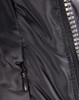 A close-up of a heavy quilted black puffer jacket featuring a zip and a side pocket. It has a logo on the front.