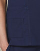 A deep navy scrub top featuring a pocket detail and contrast stitching. Includes a small logo on the garment.