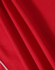 A red polo shirt made from a textured fabric, featuring a subtle branding logo.