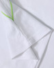 A white kids' polo shirt with green accents around the collar and sleeve edges, featuring a logo.