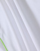 A white polo shirt with a green trim, featuring a textured fabric and a logo.