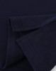 A close-up of a navy blue cotton stretch polo shirt, showcasing the fabric and folded sleeves. It features a logo.
