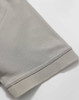 A close-up of a light grey polo shirt sleeve, featuring a solid hem and a smooth fabric texture.