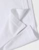 A close-up of a white polo shirt featuring a folded hem and a subtle logo.